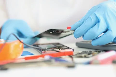 Professional fixing broken cellphone, put phone cover, handyman work in gloves Stock Photos