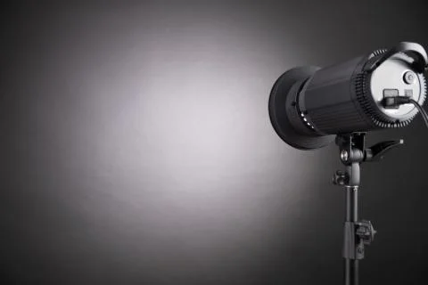 Professional flash pulsed light directed to the black wall. Stock Photos