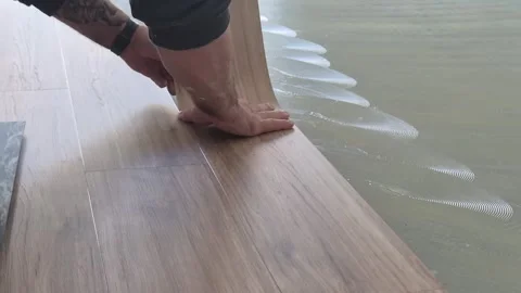 Professional Flooring Installer Placing Self-Adhesive Vinyl Plank Stockbeeldmateriaal 334334951