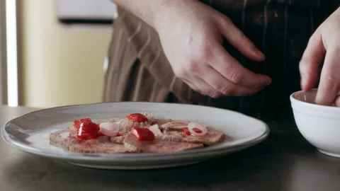 Professional focused chef carefully placing sliced onion on top of pieces of vea Video stock 199463128