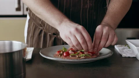 Professional focused chef carefully placing ingredients onto a plate in interior Stock Footage 199463791
