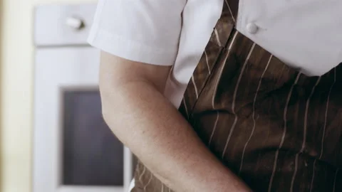 Professional focused chef carefully sprinkling green herbs onto a plate in inter Stock Footage 199459633