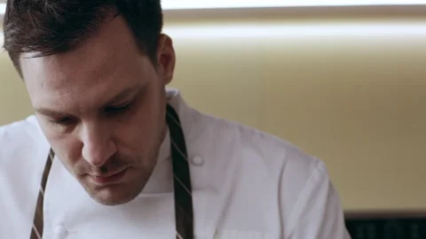 Professional focused chef dripping sauce with a spoon over pieces of veal on a p Video stock 199456128