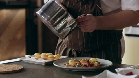 Professional focused chef pouring a spoonful of sauce over a finished plate in i Video stock 199461204