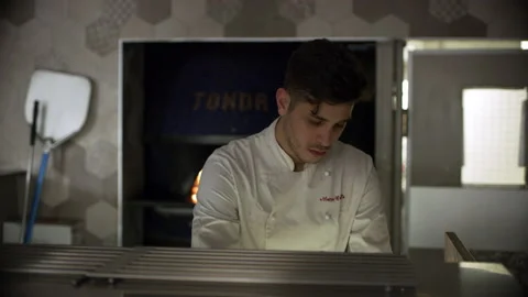 Professional focused pizza chef kneading pizza dough and tossing pizza dough int Stock Footage 199460138