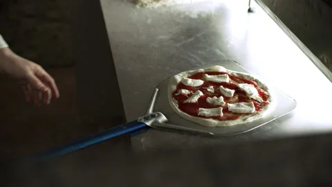 Professional focused pizza chef preparing a pizza and putting it into the stone Video stock 199462590