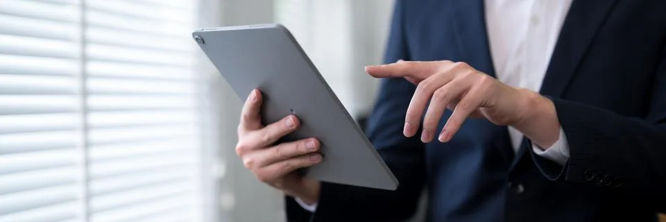 Professional in formal suit using digital tablet for business task at moder.. Stock Photos