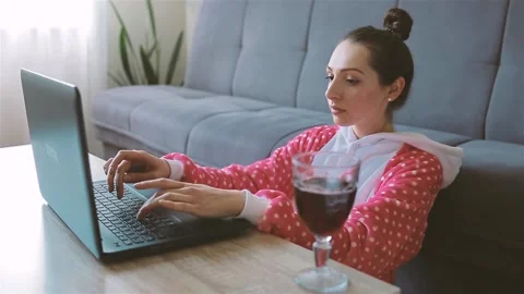 Professional freelancer types on laptop and drinks red wine Stock Footage 130321823