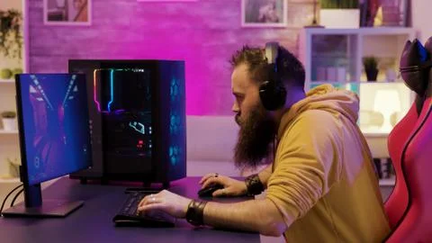 Professional game player wearing headphones in a room with colorful neons Stock Photos