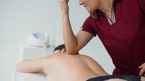 Professional gentle massaging client back muscles in white background, 4K Stock Footage 169390781