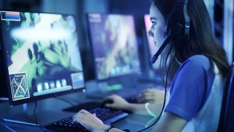 Professional Girl Gamer Plays in MMORPG or Strategy Video Game on Her  Computer. She's Participating in