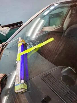 Professional glass repair process using ultraviolet lamp secured with tape .. Fotos de archivo