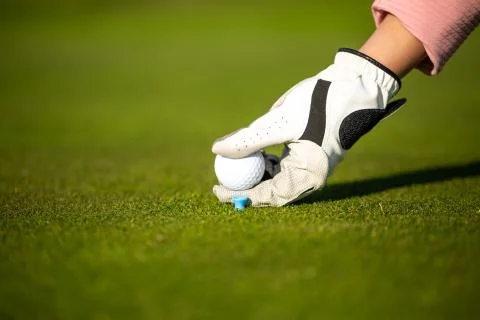 Professional golf player setting up the golf ball on a stand on grass during Stock Photos