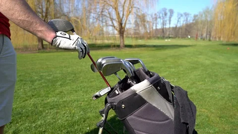 Professional golf player taking out one of clubs off bag before outdoor game. Stock Footage 128132098