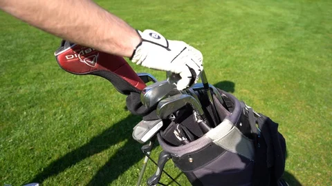 Professional golf player taking out one of clubs off bag before outdoor game. Stock Footage 128132185