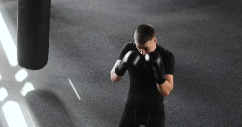 Professional guy boxer in gloves making blows training boxing in gym, top view. 스톡 동영상 126822459