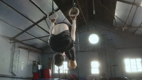 Professional Gymnast Doing Backward and Forward Rolls on Rings Stock Footage 258414082