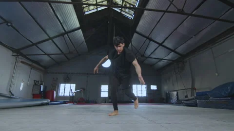 Professional Gymnast Performing Stunts while Training in Gym Stock Footage 258411471