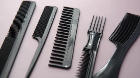 Professional hair combs set on pink background close up panoramic motion. Stock Footage 333260055