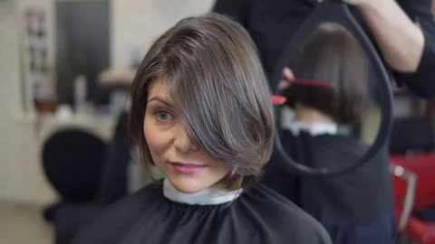 Professional hairdresser shows short haircut with mirror to handsome satisfied Stock Footage