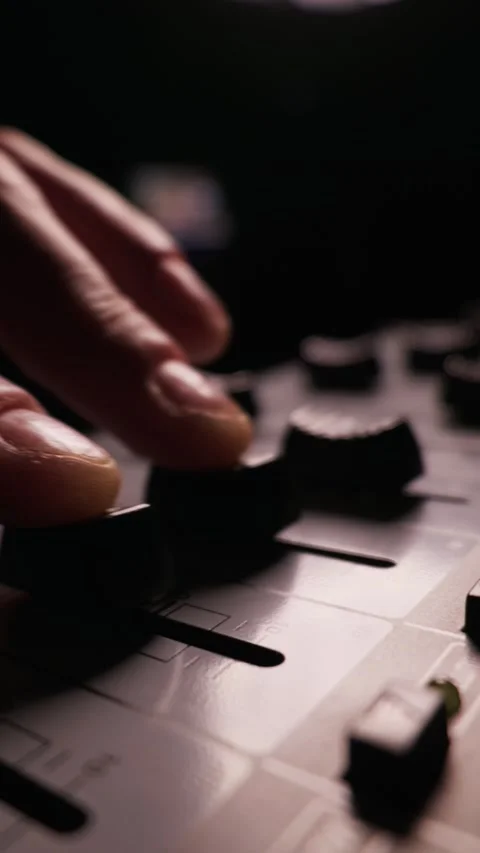 Professional Hand Adjusting Audio Mixer Fader in Dark Music Studio Environment Stock Footage 334738659