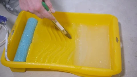 Professional handyman runs brown green brush with glue Stock Footage 108582453
