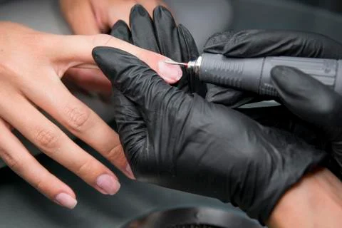 Professional hardware pedicure using electric machine. The manicurist grinded Stock Photos