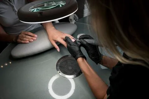 Professional hardware pedicure using electric machine. The manicurist grinded Stock Photos