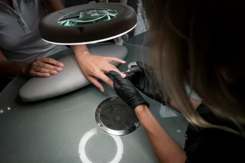 Professional hardware pedicure using electric machine. The manicurist grinded Stock Photos