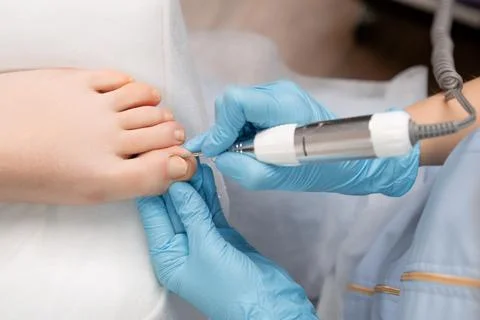 Professional hardware pedicure using electric drill machine by pedicure master Stock Photos