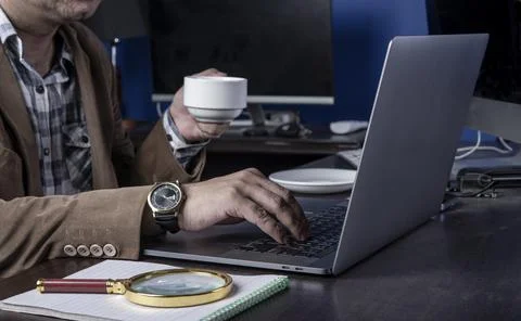 Professional holding cup of coffee while working in office Stock Photos