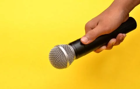 Professional holding microphone in hand while giving motivational speach Stock Photos