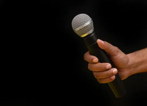 Professional holding microphone in hand while giving motivational speach Stock Photos
