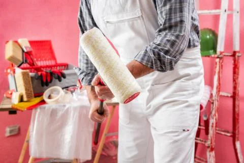 Professional house painter at work on the construction site. Stock Photos