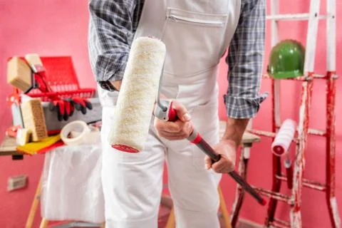 Professional house painter at work on the construction site. Stock Photos