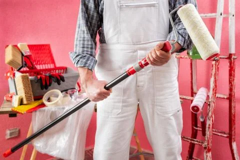 Professional house painter at work on the construction site. Stock Photos