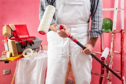 Professional house painter at work on the construction site. Stock Photos