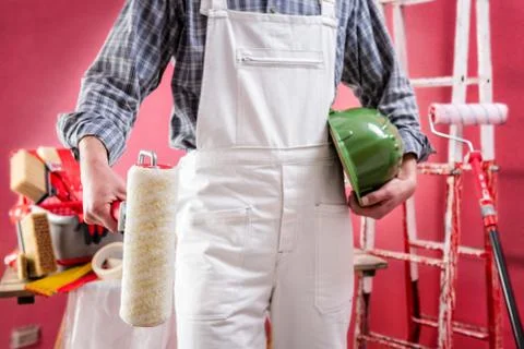 Professional house painter at work on the construction site. Stock Photos