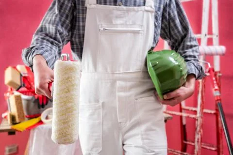 Professional house painter at work on the construction site. Stock Photos
