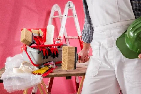 Professional house painter at work on the construction site. Stock Photos