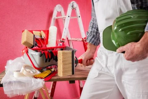 Professional house painter at work on the construction site. Stock Photos