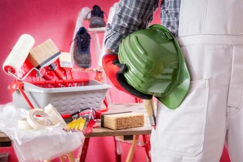 Professional house painter at work on the construction site. Building. Stock Photos