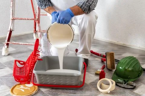 Professional house painter at work prepares the wall paint Stock Photos