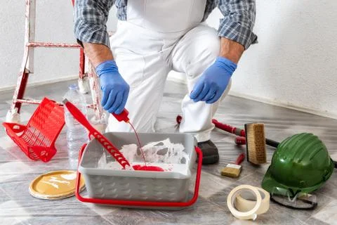 Professional house painter at work prepares the wall paint Stock Photos