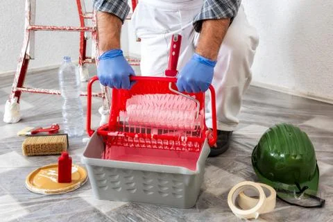 Professional house painter at work prepares the wall paint Stock Photos