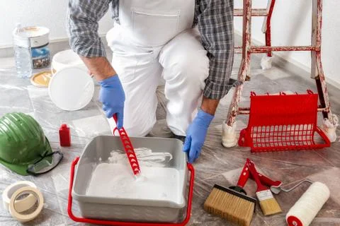 Professional house painter at work prepares the wall paint Stock Photos