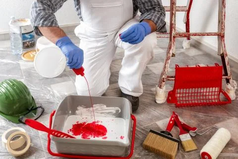 Professional house painter at work prepares the wall paint Stock Photos