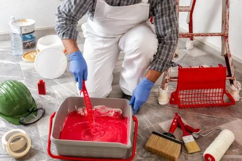 Professional house painter at work prepares the wall paint Stock Photos