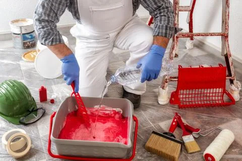 Professional house painter at work prepares the wall paint Stock Photos