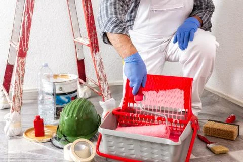 Professional house painter at work with the roller Stock Photos
